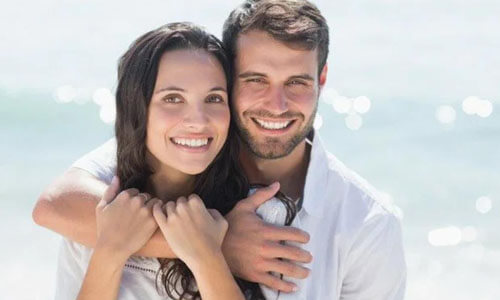 Picture of a man,  happy with his hair transplant  procedure he had in San Jose, Costa Rica.  The man is shown with his arm around a woman and both are smiling at the camera.