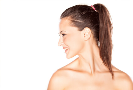 Picture of a woman with long brown hair, slightly turned to the side of the camera and happy with her perfect ear surgery procedure she had at Top Plastic Surgeons in beautiful San Jose, Costa Rica.  The angle of the camera clearly shows one ear.