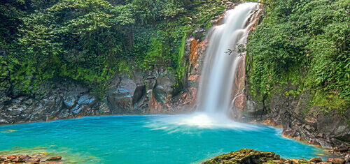 Picture of a beautiful cascading waterfall in Costa Rica. Also in the picture is a blue lake created by the waterfall.